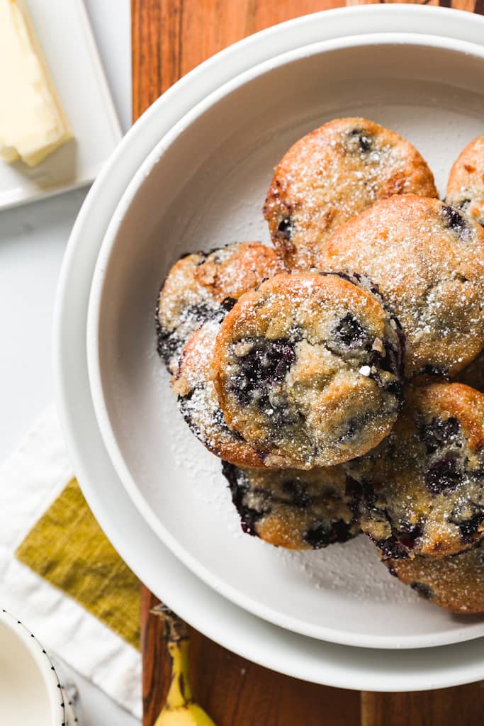  The Best Vegan Blueberry Muffin recipe with muffins on a white plate.